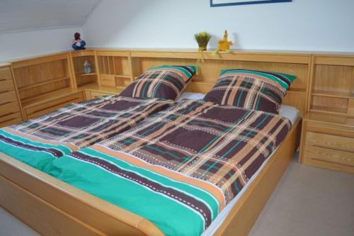 a bedroom with a wooden bed with two pillows at Almer Ferienwohnung in Brilon