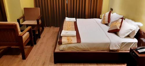 Un dormitorio con una cama grande con almohadas. en Punakha Residency en Punākha