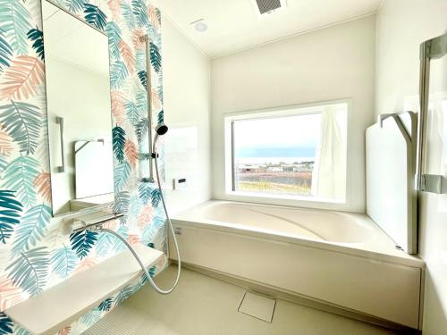 a bathroom with a tub and a window at BEACH HOUSE Kamogawa - Vacation STAY 64005v in Kamogawa