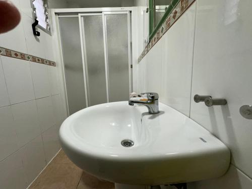 ein weißes Waschbecken im Bad mit Dusche in der Unterkunft 2 dormitorios 95 m de la playa in Los Alcázares