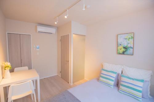 um pequeno apartamento com uma cama, uma mesa e uma secretária em The most comfortable and best choice for accommodation in Yoyogi YoSi2 em Tóquio