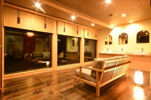 a living room with a bench and a kitchen at Koyasan Shukubo Yochiin in Koyasan