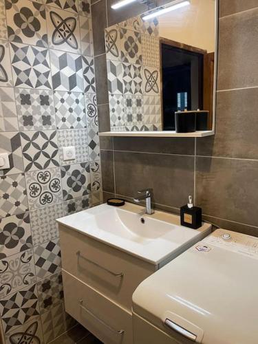 une salle de bain avec un lavabo et un miroir dans l'établissement Bas de villa pour 6, à Venzolasca