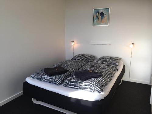 a bed in a room with two black pillows on it at Siesta Vejle in Vejle