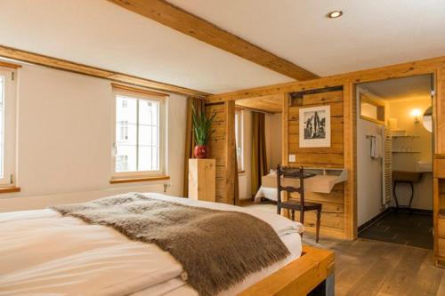 a bedroom with a bed and a desk in it at Boutique Hotel The River House in Andermatt