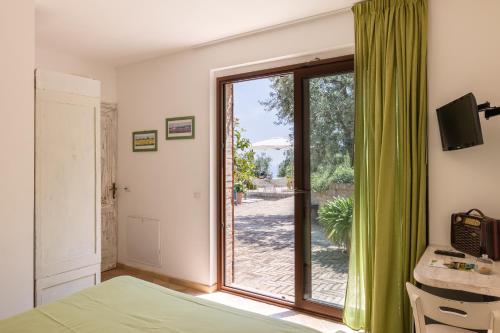 サン・ベネデット・デル・トロントにあるVilla Cri Cri B&B di Charmeのベッドルーム1室(ベッド1台付)、スライド式ガラスドアが備わります。