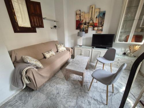 een woonkamer met een bank en een tv bij Catedral Suite in Granada