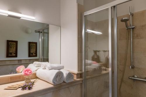 bagno con asciugamani su un bancone e specchio di Villa Cri Cri B&B di Charme a San Benedetto del Tronto