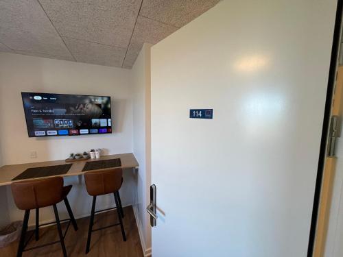 a room with a bar with two stools and a tv at Go-Sleep Bredehus in Bredsten