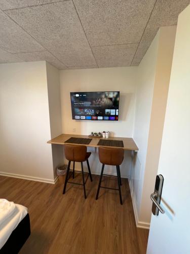 a room with a desk with two chairs and a tv at Go-Sleep Bredehus in Bredsten