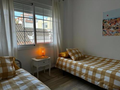 sypialnia z 2 łóżkami i stołem z lampką w obiekcie TuHome Neptuno I w mieście Fuengirola