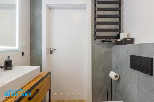 a bathroom with a white sink and a staircase at Apartamenty BlueSky Kąpielowa 5B - widok na góry, blisko wyciągów i szlaków in Karpacz