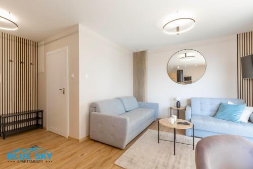 a living room with a blue couch and a chair at Apartamenty BlueSky Kąpielowa 5B - widok na góry, blisko wyciągów i szlaków in Karpacz