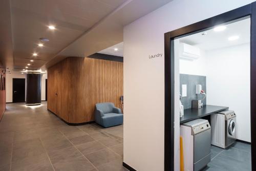 a hallway with a chair and a washer and dryer at Aparthotel Colombo Roma in Rome