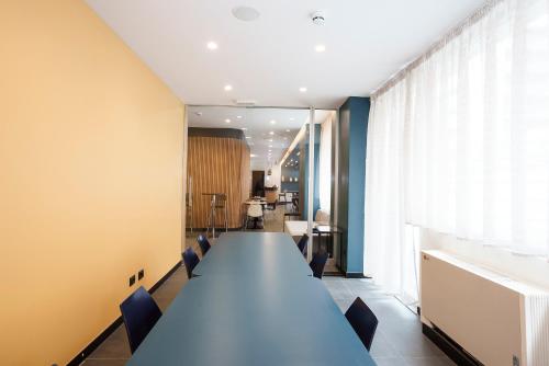 Aparthotel Colombo Roma في روما: قاعة المؤتمرات مع طاولة وكراسي طويلة