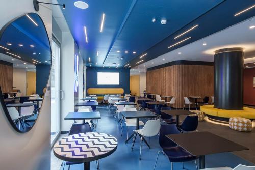 a restaurant with tables and chairs and a screen at Aparthotel Colombo Roma in Rome