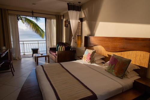 een slaapkamer met een bed en uitzicht op de oceaan bij Mantis Soanambo Hotel And Spa in Sainte Marie