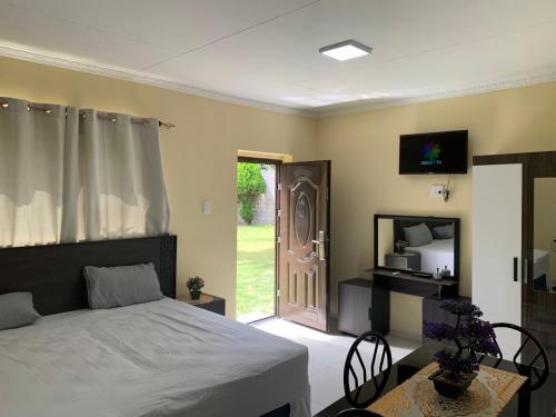 um quarto com uma cama e uma porta para um quintal em First Class Lodge em Benoni