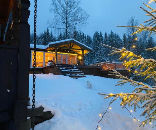 una cabaña de madera en la nieve por la noche en Panorama Cabin with 5-bedrooms near Norefjell, en Gubberud