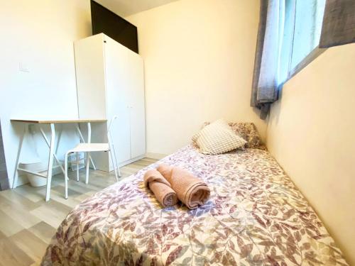 1 dormitorio con 1 cama con 2 toallas en Apartamento Compartido a 15 minutos de la Playa en Valencia, en Valencia