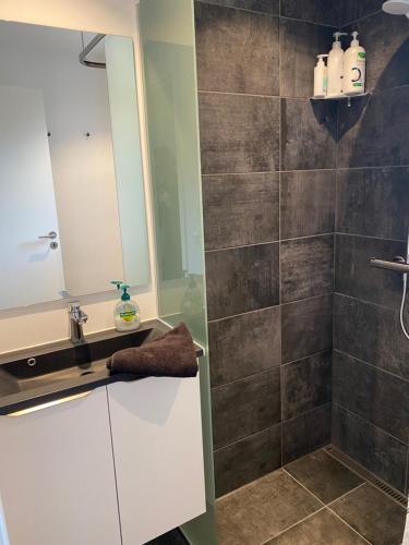 a bathroom with a sink and a shower with a mirror at Siesta Vejle in Vejle