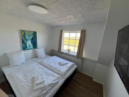 a small bed in a room with a window at Go-Sleep Bredehus in Bredsten