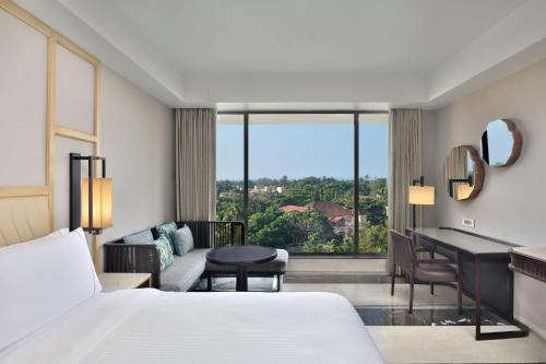 a hotel room with a bed and a living room at The Westin Goa in Vagator