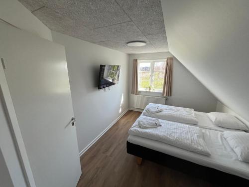 a white bedroom with a bed and a window at Go-Sleep Bredehus in Bredsten