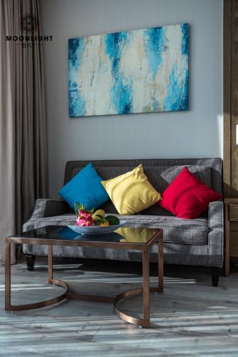 a living room with a couch with colorful pillows at Moonlight Bay Panorama Condotel Ocean View in Nha Trang