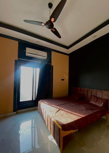een slaapkamer met een bed en een plafondventilator bij Lost &Found in Bhopal