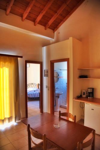 a dining room with a table and a bedroom at Apartments Hotel & Studios, Xifoupolis in Monemvasia