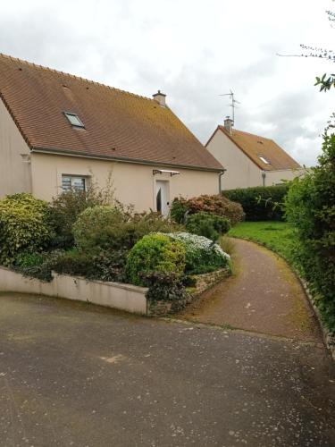 a house with a walkway in front of it at Appartement tout confort in Le Fresne-Camilly