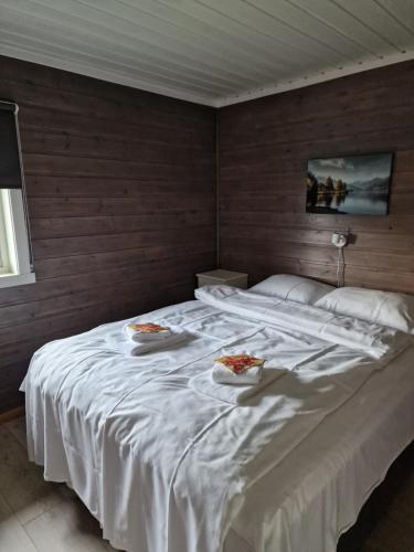 a bedroom with a large white bed with two plates on it at Innvik Fjordcamp in Innvik