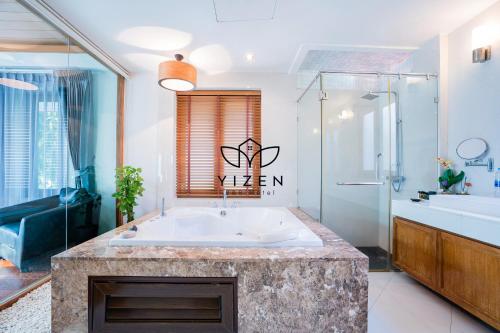 Un baño con bañera grande y ducha. en Yizen Beachfront Seaview Villa, en Norte de Pattaya