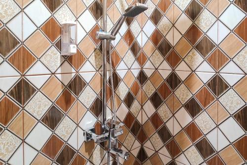 a bathroom with brown and white tiled walls at RedDoorz Syariah near Telanaipura Jambi in Jambi