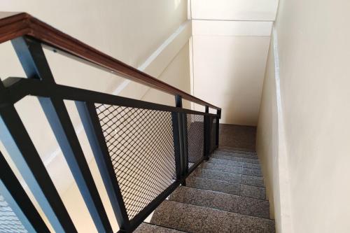 a staircase in a house with a black railing at RedDoorz Syariah near Telanaipura Jambi in Jambi