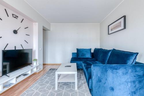 a living room with a blue couch and a clock at Kesklinna majutus in Haapsalu