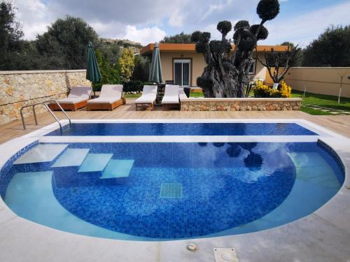 a pool with blue water in a yard at Villa MATA - 600m² with Private Pool and Jacuzzi in Kalithies