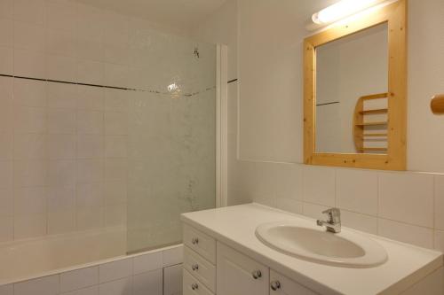 a bathroom with a sink and a mirror and a tub at Meijotel - 508 - Appart duplex - 6 pers in Les Deux Alpes