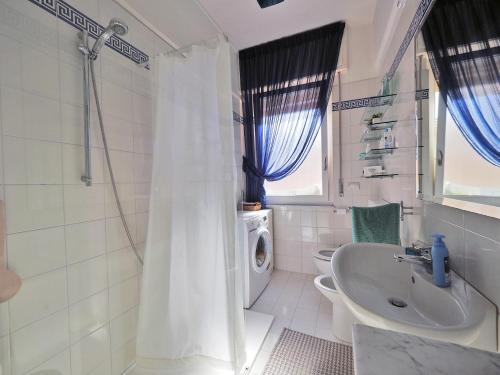 uma casa de banho branca com um chuveiro e um lavatório. em Felicitas (Charming House) em Lerici
