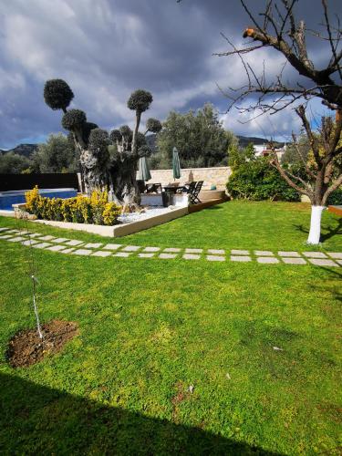 a garden with a pool and a table and chairs at Villa MATA - 600m² with Private Pool and Jacuzzi in Kalithies