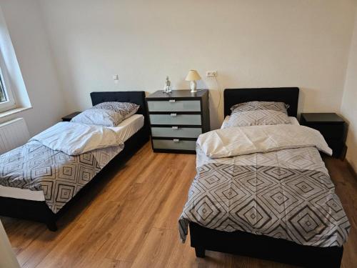 a bedroom with two beds and a dresser in it at Ferienwohnung Hambergen in Hambergen
