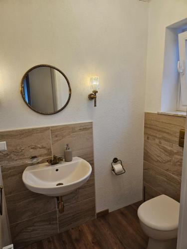 a bathroom with a sink and a toilet and a mirror at Ferienwohnung Hambergen in Hambergen