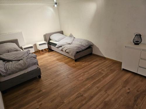 1 dormitorio con 2 camas y suelo de madera en Ferienwohnung Hambergen en Hambergen