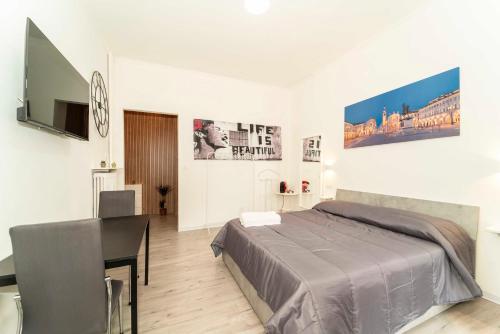 a bedroom with a bed and a table and a desk at SUITE INALPI ARENA STADIO OLIMPICO TORINO in Turin