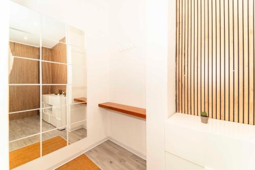 a walk in closet with white walls and wood accents at SUITE INALPI ARENA STADIO OLIMPICO TORINO in Turin