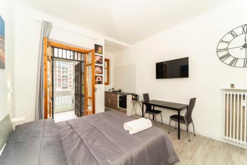 a bedroom with a bed and a table and a television at SUITE INALPI ARENA STADIO OLIMPICO TORINO in Turin