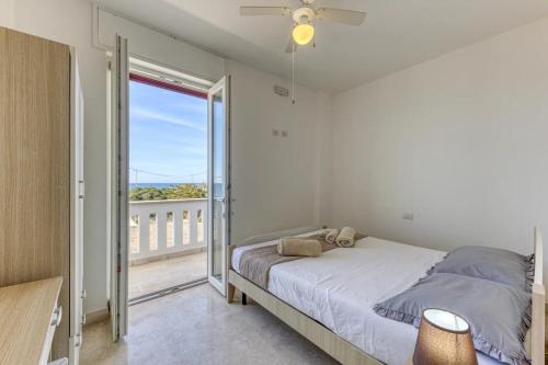 a bedroom with a bed and a balcony at Camere arcobaleno fronte mare a Torre san Giovanni in Torre San Giovanni Ugento