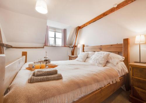 een slaapkamer met een groot bed met een houten hoofdeinde bij Smugglers Retreat in Wells next the Sea