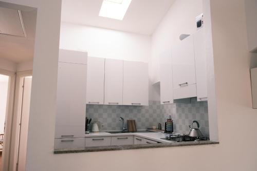 San Lorenzo della CostaにあるVilla Costa by PortofinoVacanzeの白いキッチン(白いキャビネット、シンク付)